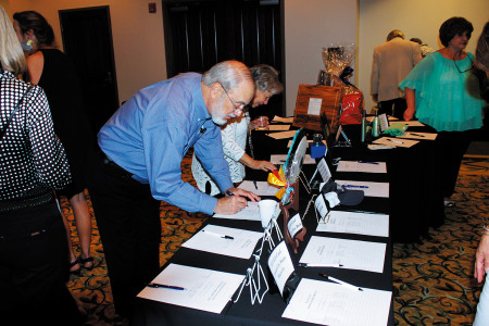 Benefit participants  silent auction featured more than 100 items. Above, Father Joe Tonos, pastor, welcomes.  (Photo by Gene Buglewicz)