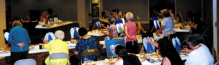 Celeste Zepponi (front, left) guides the 18 women who participated in the art session of a workshop to paint an angel. The focus of the morning session was  the Holy Spirit and God’s dreams for us. (Photo by Jessica Sullivan)