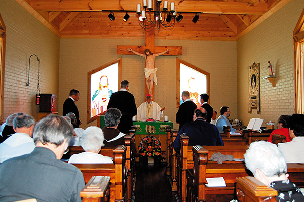 Bishop Joseph Kopacz prays the prayer of commissioning for the four Redemptorist priests as members of the Hispanic ministry initiative in the Mississippi Delta. The Mass was celebrated in the newly built Chapel of Mercy on the grounds of the Locus Benedictus Retreat Center. (Photo by Elsa Baughman) 