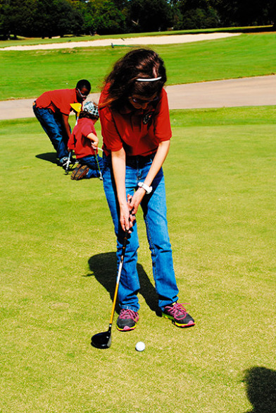 Before Special Kids Golf Tournament last year, Mary F. practiced putting. 