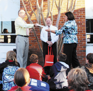 Steve Lowry and Les Kevehazi, representatives from Scholastic Books, present Annunication School principal Joni House, with an award for reading the most number of minutes in the state. This is the second year the school has won the summer reading challenge sponsored by Scholastic. (Photo by Heather Skaggs)