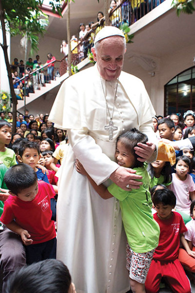 Pope Francis is embraced by a child at a home for former street children in Manila, Philippines, Jan. 16. (CNS photo/L’Osservatore Romano via Reuters)