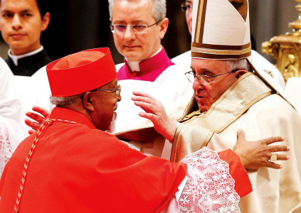 Pope Francis greets new Cardinal Berhaneyesus Souraphiel of Addis Ababa, Ethiopia, after presenting a red hat to him during a consistory in St. Peter’s Basilica Feb. 14. (CNS photo/Paul Haring)