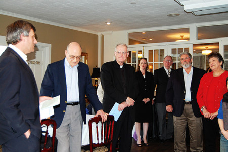 JACKSON – Aad deLange (left) speaks at a reception to honor Msgr. Elvin Sunds, center, outgoing Vicar General, and Rosemary Grantham, right, retiring secretary in the office of Temporal Affairs, on Thursday, Feb. 19. Msgr. Sunds served as vicar for almost a dozen years. Grantham has worked in the chancery for 20 years. (Photo by Elsa Baughman)