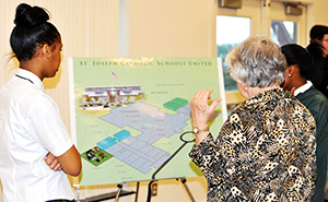 Students and supporters look at plans to add classrooms to St. Joseph to accommodate Our Lady of Lourdes students. 
