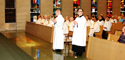 Deacon Jason Johnston surrounded by brother clergy during his ordination at St. Paul Parish. (Photos by Maureen Smith)