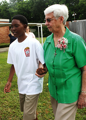 ay Robinson walks Sister Mary Elizabeth DeBoer to her seat.