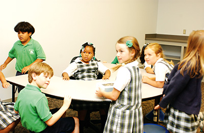 First-graders Fredy R., Brooks G., Radiance S., Audrey R., Noelle S. and Emma W. try out one of the new collaboration tables while they tour the new rooms.