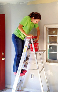 A volunteer for Sacred Heart Southern Missions paints a home in North Mississippi. 