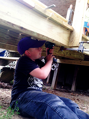 Nine-year-old Jake Dixon works on a wheelchair ramp with his family. 