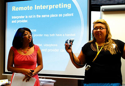 Laura Rivera, (right) an interpreter supervisor at the Department of Human Services’ Division of Family and Children’s Services in Jackson, explains how to use the interpreter audio equipment during the training. Shirley Pandolfy (left), operations management analyst principal, was one of the instructors of the 40-hour workshop. (Photo by Elsa Baughman)