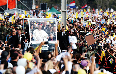 ASUNCION, Paraguay – El Papa Francisco pasea por las calles alrededor del Parque Nu Guazu en Asunción el día de su llegada al país el 12 de julio. El papa visitará a Cuba del 19 al 22 de septiembre y tres ciudades en los Estados Unidos durante su visita del 22 al 27 de septiembre. El sumo pontífice celebró misa ese día en Asunción. (CNS foto/Paul Haring)) 