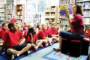 Annunciation school librarian Terri Doumit reads to students in the library. Doumit is the driving force behind a very successful summer reading program, which has resulted in three Scholastic Summer Reading Program awards in three years. (Photo by Katie Fenstermacher)