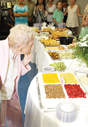 Mafalda Barraco recieves a cake for her 100th birthday at a reception after Mass.