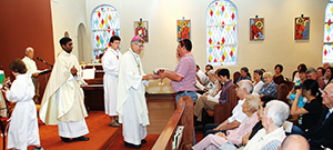 Philadephia – Bishop Joseph Kopacz visited Holy Cross Parish Sunday, Sept. 20. Brian and Rachel Dunn present the gifts to Bishop Kopacz during Mass while altar server Sam Knight, Father Augustine Palimattam, pastor, and altar server Eli Moran wait to assist.