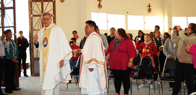 El Obispo Joseph Kopacz camina dentro de la nueva capilla, Divina Misericordia, bendiciendo a la comunidad reunida para la misa de consagración. El obispo también bendijo las Estaciones de la Cruz y prendió las velas de las paredes.