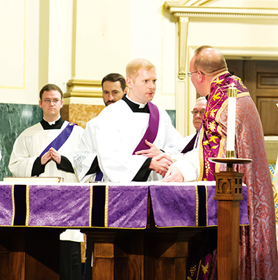 Deacon Jason Johnston accepts congratulations from Notre Dame Seminary Rector Father James Wehner after his profession of faith. (Photo courtesy of Notre Dame Seminary)