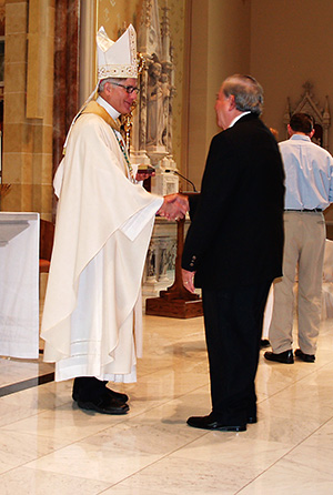 El Obispo Joseph Kopacz le entrega al Dr. Luis Borrell la medalla Obispo Chanche en reconocimiento a su servicio en la Parroquia San José en Meridian. En el 2014, Enrique Amador y Carolina Fiero, miembros de la Parroquia San James en Tupelo recibieron la medalla. (Foto de Maureen Smith)