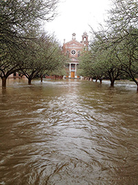 A photo from Friday, March 11, shows water creeping up the steps of the church at St. Joseph’s abbey. The water has dropped, but damage remains. (Photo courtey of Rhonda Bowden) 