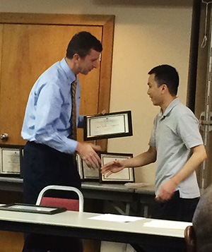 Father Binh Nguyen, associate pastor at Madison St. Francis of Assisi Parish, accepts his certificate from Matt Manion, president of Catholic Leadership Institute. (Photo by Father Kevin Slattery)