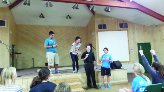 Young people broke into small groups for reflection activities. At left, a group of boys has a discussion about faith. The team also led an icebreaker with (l-r) Austin Cabral, NET member from Hilmar, Calif.; Cori Matsumiya, NET member from Orange, Calif.; Aaron Williams, seminarian from Jackson and John Baladi, from Gluckstadt St. Joseph Parish. (Photos courtesy of Abbey Schuhmann)