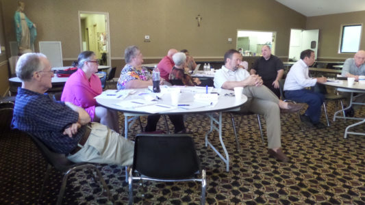 The Envisioning Team includes members from across the diocese including (l-r) Msgr. Elvin Sunds, Jackson St. Therese pastor, Danna Johnson, Pontotoc St. Christopher; Kris Ivancic, Tupelo St. James; Thomas Harris, Flowood St. Paul. At the back table Terry Casserino, Madison St. Joseph School sits with Jane Letchworth, Joyce Hart and Father Kevin Slattery, Vicar General. Lorenzo Aju, Houston Immaculate Heart of Mary and Thomas Welch are visible to the right. Other members are not pictured.  
