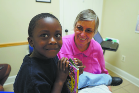 The late Sr. Paula Merrill, SCN, visiting with a patient at the Lexington Medical Clinic in this file photo. She is one of many Sisters of Charity of Nazareth serving around the world. (File Photo)