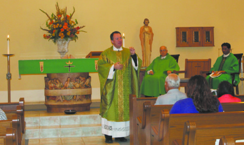 Father Jeffrey Waldrep, former pastor of Immaculate Conception Parish, speaks about his childhood in the community at the homecoming Mass celebrated to close the Year of Mercy. Father Sam Messina, former pastor, and Father Channappareddy Basani, present pastor, concelebrated. (Photo courtesy of Lynn Kyle)