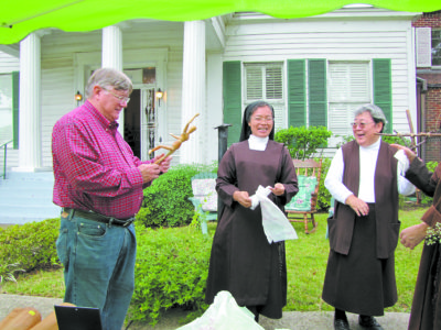 In this file photo from 2015, Sister Mary Jane of the Resurrection (right) shares a laugh with Sister Cor Christi Abenio and Lloyd Chatham during the art show of Sister Mary Muriel Ludden, a Discalced Carmelite nun who died in 2013.(Photo by Elsa Baughman)