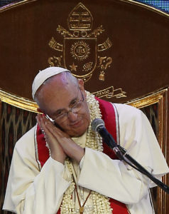 Pope Francis shows the sleeping posture of a statue of St. Joseph he keeps on his desk while giving a talk during a meeting with families in the Mall of Asia Arena in Manila, Philippines, Jan. 16. The pope spoke about his devotion to St. Joseph, foster-father of Jesus, and his practice of writing prayers on pieces of paper and slipping them under the statue so St. Joseph could sleep on them. (CNS photo/Paul Haring) See PHILIPPINES-MARRIAGE Jan. 16, 2015.