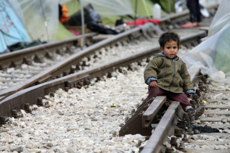 A child sits on railroad tracks near a makeshift camp for migrants in late March at the Greek-Macedonian border near the village of in Idomeni, Greece. Children are the most vulnerable and hardest hit among the world's migrants and require special protection, Pope Francis said. (CNS photo/Armando Babani, EPA) See POPE-MIGRANTS-MESSAGE Oct. 13, 2016.