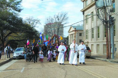 JACKSON – Members of St. Peter Parish, accompanied by Father Anthony Quyet (center) walk around the downtown area in procession praying the rosary Sunday, Dec. 11, for the celebration  of the feast of Our Lady of Guadalupe. (Photo by Elsa Baughman)