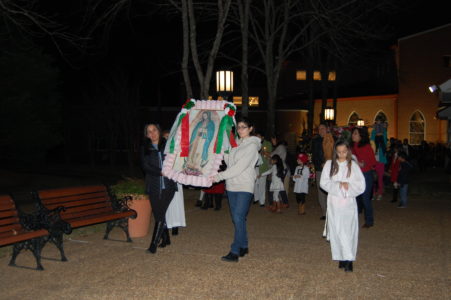 MADISON – Pilar Terrazas (left) and Michelle McLean carry the banner with the image of the Virgin of Guadalupe in procession toward St. Francis of Assisi while the congregation sings Sunday, Dec. 11. This is the first time the feast of Our Lady of Guadalupe has been celebrated at the parish. Fathers Albeenreddy Vatti, pastor, Jason Johnston and Msgr. Michael Flannery celebrated the Eucharist at 7 p.m. 