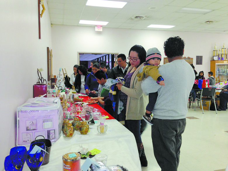 JACKSON – St. Therese parishioners select gifts during the “CWA Christmas shopping days” held Nov. 26-27 and Dec. 3-4 after all Masses. All proceeds from this sale and the tamale sale will go to the 2016 Catholic Habitat Build on Greenview Street. (Photo by Elsa Baughman)