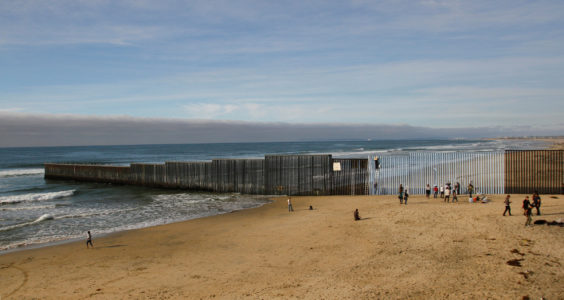 People in Tijuana, Mexico, stand next to a wall separating Mexico and the United States Dec. 10. (CNS photo/Jorge Duenes, Reuters) See USCCB-WORKING-GROUP-MIGRANTS Dec. 16, 2016.