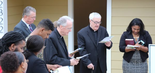 Msgr. Elvin Sunds, pastor of Jackson St. Therese Parish prays as Bishop Emeritus Joseph Latino blesses the new Habitat Home on Greenview Dr. in Jackson. 