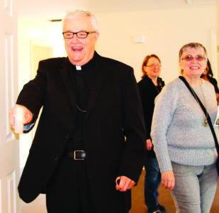 JACKSON – Bishop Emeritus Joseph Latino blessed every room of the newest Habitat for Humanity Home on Greenview Drive in South Jackson on Wednesday, Jan., 25. At left, volunteers, area pastors and sponsors gathered for the dedication and blessing. This is the 31st home built as part of Catholic Build. (Photos by Peggy Hampton) 